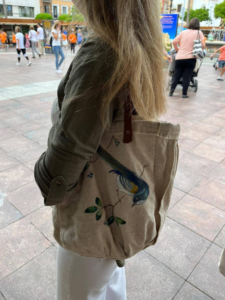 Bolso artesanal en tela con pintura de un ave, diseño decorativo hecho a mano.