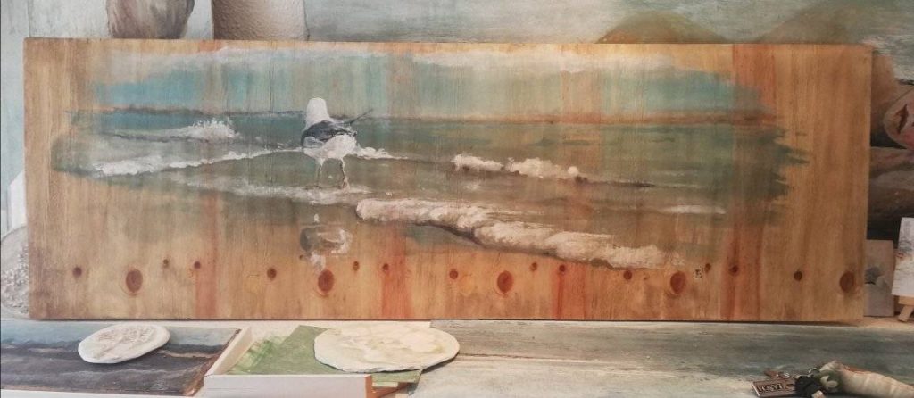 Pintura de paisaje marino realizada sobre tabla de madera, arte decorativo artesanal.